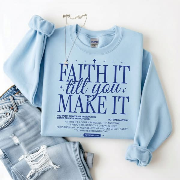 blue sweatshirt with it text reading faith it till you make it on white background