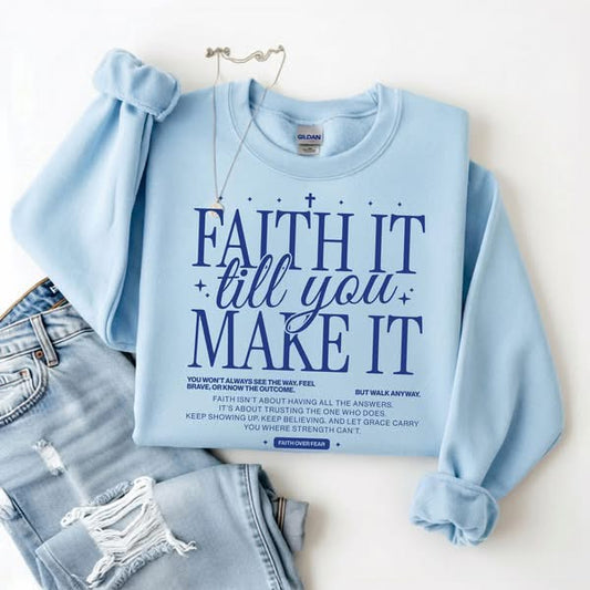 blue sweatshirt with it text reading faith it till you make it on white background